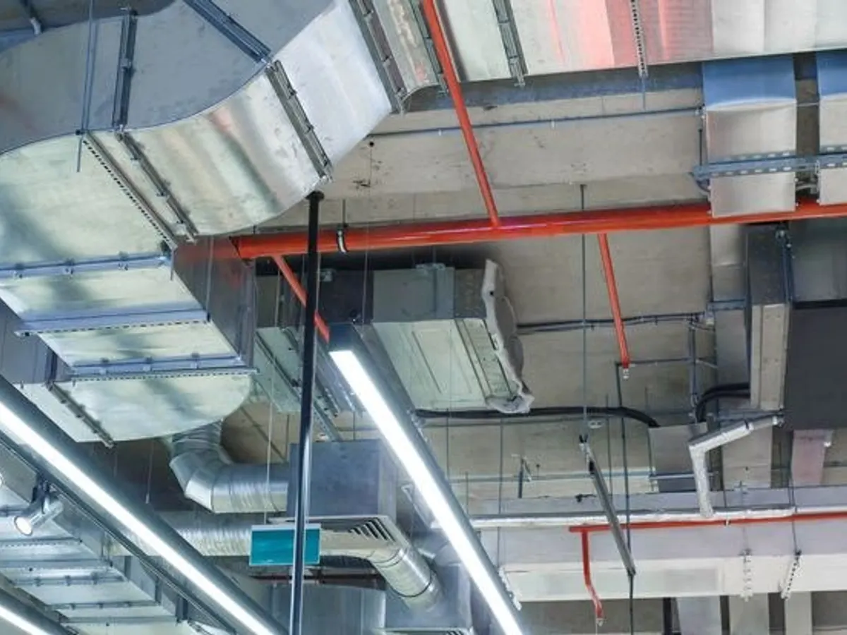 Coordinated ductwork and pipework installed below an exposed soffit